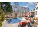 Outdoor pool area with lounge chairs, hot tub, and mature landscaping at 12441 Morning Creek Ln, Charlotte, NC 28214