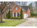 Brick home showcasing an attached two-car garage and a well-kept lawn at 140 Melbourne Dr, Fort Mill, SC 29708