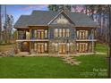 Stately two-story home featuring stone and siding, balconies, and multiple entry points to a large green lawn at 1547 Sunset Pointe Dr, Salisbury, NC 28146