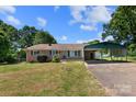 Charming brick home with a covered carport on a sunny day, showcasing its inviting facade at 208 Caleb Rd, Shelby, NC 28152