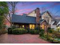 Inviting rear exterior features a screened porch, brick facade, and meticulously maintained landscaping at 2924 Chelsea Dr, Charlotte, NC 28209