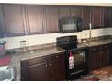 Kitchen showcasing dark cabinetry, modern black appliances and laminate counters at 3627 Alexander Forest Dr, Charlotte, NC 28269