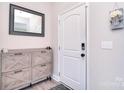 Bright foyer with white door, gray accents, stylish wooden cabinet, and modern mirror at 4017 Avis Way, Monroe, NC 28110