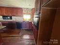 Kitchen featuring wood cabinets, dishwasher, microwave, and oven at 409 S Martin Luther King Jr Ave, Salisbury, NC 28144