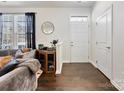 Bright entryway with hardwood floors and a cozy seating area with a stylish round mirror at 4107 Audubon Park Dr, Charlotte, NC 28217
