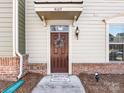 Close-up of a welcoming front door with a decorative wreath and stylish exterior lighting at 4107 Audubon Park Dr, Charlotte, NC 28217