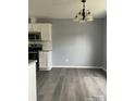 Open dining area features hardwood floors, neutral paint, modern lighting fixture and stainless steel appliances at 4226 Red Shed Ln, Charlotte, NC 28269