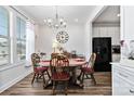 Cozy dining room features a round wooden table, chairs, and a stylish chandelier above at 7336 Overjoyed Xing, Charlotte, NC 28215