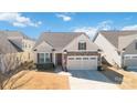 Inviting home exterior with a manicured lawn, two-car garage, and appealing architectural details at 7336 Overjoyed Xing, Charlotte, NC 28215