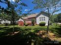 Spacious backyard with a wooden deck, perfect for outdoor entertaining, surrounded by mature trees at 7700 Sedgebrook E Dr, Stanley, NC 28164