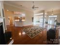 Open living room showcasing hardwood floors, fireplace, and open layout to kitchen and dining area at 7700 Sedgebrook E Dr, Stanley, NC 28164