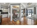 Elegant foyer with hardwood floors, decorative columns, chandelier, and a formal dining area at 9332 Whistling Straits Dr, Fort Mill, SC 29707