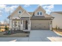 Charming home with stone accents, a gray two-car garage, well manicured flower beds, and covered front porch at 1113 Idyllic Ln, Waxhaw, NC 28173