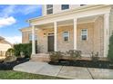 Charming brick home featuring a covered front porch with stately columns, beautiful landscaping, and inviting curb appeal at 182 Walking Horse Trl, Davidson, NC 28036