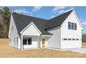 Charming exterior features white siding, black trim, a covered porch, and an attached garage at 2095 Tite Rd, Stanfield, NC 28163