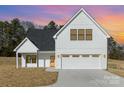 Beautiful exterior view of new construction home features a white facade, black trim, and attached two car garage at 2095 Tite Rd, Stanfield, NC 28163