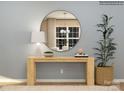 Modern entryway featuring a sleek table, decorative mirror, stylish lamp, and potted plant at 250 Tackle Box Dr, Troutman, NC 28166