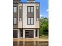 Contemporary townhome featuring a dark garage door, contrasting siding, and manicured green spaces at 3206 Riley Ave, Charlotte, NC 28269