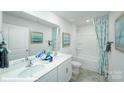 Bright bathroom featuring double sinks, a large mirror, and a combined shower and tub at 8043 Plymouth Rd, Sherrills Ford, NC 28673