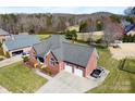 Aerial view of brick home with lush lawn, attached two-car garage and manicured landscaping at 9016 Heather Trce, Gastonia, NC 28056