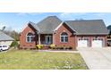 Charming brick home featuring a manicured lawn, attached two-car garage, and covered front porch at 9016 Heather Trce, Gastonia, NC 28056