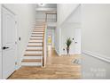 Inviting entryway featuring hardwood floors, staircase, and a view into other rooms, bright and airy at 10211 Ridgewell Ct, Charlotte, NC 28215