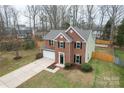 Two-story brick home with attached garage, gray roof, and manicured lawn at 10211 Ridgewell Ct, Charlotte, NC 28215
