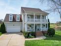 Charming two-story home with a welcoming porch and well-manicured landscaping at 139 Tenth Green Ct, Statesville, NC 28625