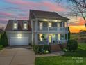 Charming two-story home with a welcoming porch and well-manicured landscaping at dusk at 139 Tenth Green Ct, Statesville, NC 28625