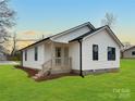 Beautiful white house with black trim, an entrance to the backyard, and a spacious lawn at 141 Ark St, Kings Mountain, NC 28086
