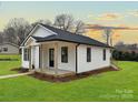Attractive single-story home featuring a welcoming front porch, black framed windows, and a well-maintained yard at 141 Ark St, Kings Mountain, NC 28086