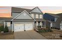 Charming gray two-story home with a two-car garage, inviting front porch, and well-maintained landscaping at 1426 Whitman Ct, York, SC 29745