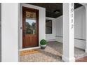 Inviting front porch featuring a wood door, brick flooring, and a 'welcome' mat at 16112 Terry Ln, Huntersville, NC 28078
