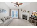 Bright living room features a ceiling fan, fireplace, and access to a balcony at 16614 Amberside E Rd, Cornelius, NC 28031