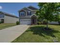 Traditional two-story home with a stone-accented entrance and attached two-car garage nestled on a green lot at 173 Glastonbury Dr, Mooresville, NC 28115