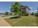 Landscaped front yard features a lush lawn and young trees, enhancing the home's curb appeal at 173 Glastonbury Dr, Mooresville, NC 28115