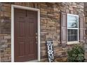 Inviting front entrance with stone detail, decorative shutters, and a welcoming brown door at 173 Glastonbury Dr, Mooresville, NC 28115