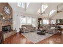 Sun-filled living room featuring a stone fireplace, skylights, and plush seating at 1812 Mill Chase Ln, Waxhaw, NC 28173