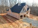 Side view of a new construction home with a two-car garage and gravel driveway at 236 Mark Ryan Ln, Dallas, NC 28034