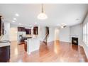 Open-concept living space with hardwood floors, a fireplace, and seamless flow into the kitchen at 2679 Southern Trace Dr, Waxhaw, NC 28173