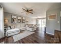 Open-concept living room with wood floors, a ceiling fan, and comfortable sectional sofa at 307 Walnut St, Clover, SC 29710