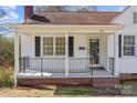 Inviting front porch featuring classic white columns, black railings, and brick foundation at 308 Knox St, Clover, SC 29710