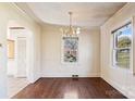 Bright dining room featuring hardwood floors, a chandelier, and natural light from two windows at 3901 Starmount Ave, Charlotte, NC 28269