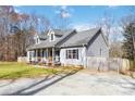 Well-maintained home with a covered front porch and gravel driveway near a wooden fence at 400 Joe Cloninger Rd, Bessemer City, NC 28016