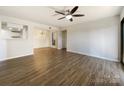 Spacious living room with hardwood floors and ceiling fan leading into a dining area with modern lighting at 4918 Sardis Rd # E, Charlotte, NC 28270