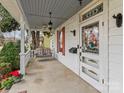 Inviting front porch featuring a porch swing, a ceiling fan, and decorative details on the door and windows at 629 S Fulton St, Salisbury, NC 28144