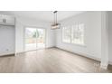 Dining area featuring hardwood floors, natural light, modern lighting, and view of the deck from the sliding door at 6535 Fisher Farm Nw Ln, Concord, NC 28027