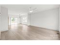 Bright and airy living room featuring hardwood floors, modern lighting, neutral paint, and slider leading to deck at 6535 Fisher Farm Nw Ln, Concord, NC 28027