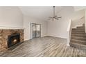 Living room featuring a stone fireplace, ceiling fan, wood floors, and stairway at 100 Willow Run Dr # 7, Gastonia, NC 28056