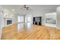 Spacious living room featuring hardwood floors, vaulted ceilings, fireplace, and large windows at 10033 Bora Bora Dv, Tega Cay, SC 29708